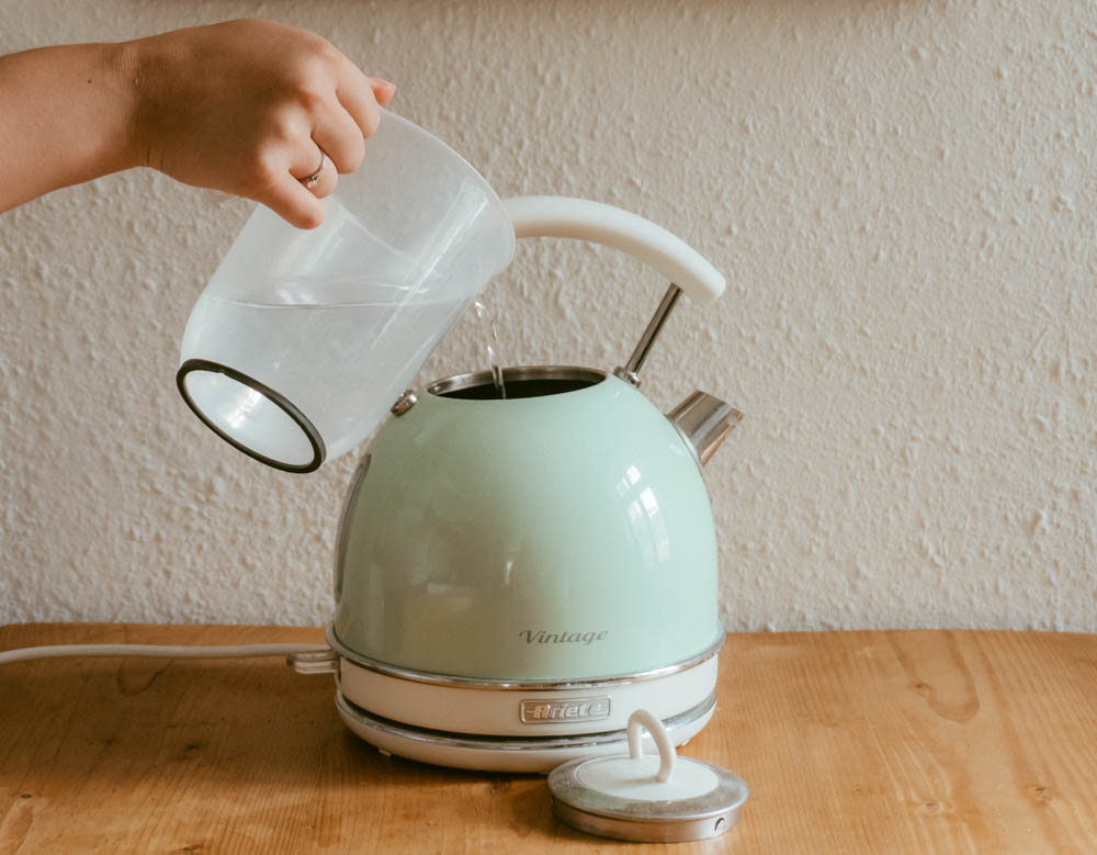 water being pored into a kettle