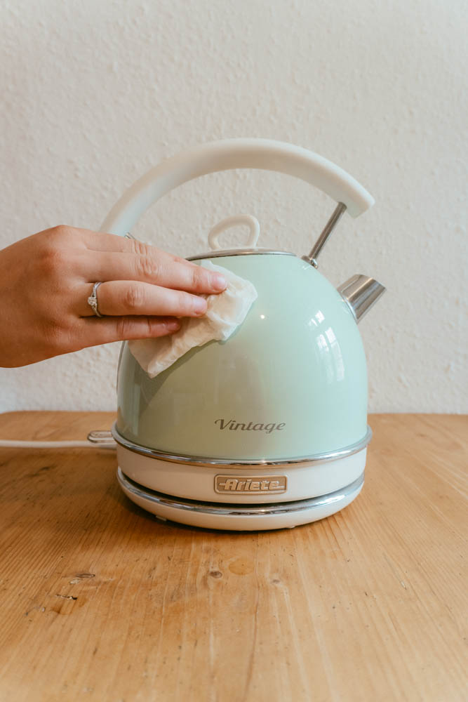 someone cleaning the outside of a kettle